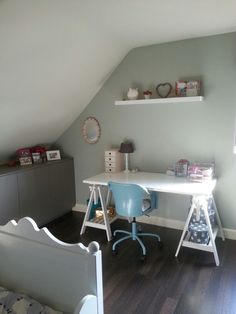 a room with a bed, desk and shelves on the wall next to each other