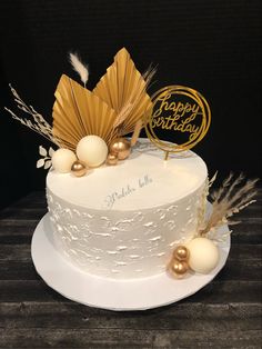 a white cake with gold decorations on top and the number 50 written on it's side