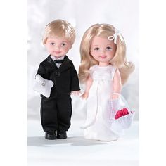 two dolls dressed in black and white are standing next to each other on a white background