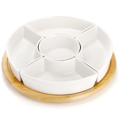 four white dishes stacked on top of each other with bamboo coasters around the edges