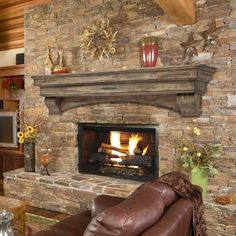 a living room with a fire place and couches in front of a stone fireplace