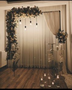 a wedding ceremony with candles and flowers on the floor in front of a curtained window