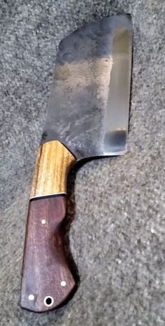 a knife that is on the ground with some kind of wood in front of it