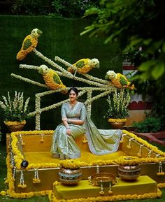 a woman sitting on top of a fake flower display