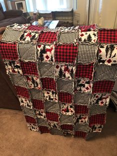 a red and black blanket sitting on top of a couch