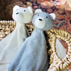 two stuffed bears are sitting in a basket