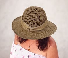 a woman wearing a green hat with a bow on it's brim and shoulder