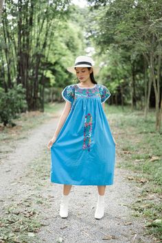 "Beautiful Mexican dress in shade of light blue with floral embroidery. Mexican traditional dress. Bright colorful floral embroidery. With White crochet lace on neck and sleeves. Tailored chest with little people on smocking. Conditions : in good vintage condition **difference color under armpits (shown in the last picture) BEST FIT = M Please be sure to check the measurements to insure a perfect fit. Details and Measurements (Inch) BUST: 46 \"measure from armpit to armpit SHOULDER TO SHOULDER: Embroidered Light Blue Cotton Dress, Blue Floral Embroidery Short Sleeve Dress, Blue Folk Style Dress With Intricate Embroidery, Blue Folk Dress With Intricate Embroidery, Light Blue Embroidered Cotton Dress, Blue Folk Embroidered Dress With Intricate Embroidery, Traditional Light Blue Summer Dress, Blue Cotton Folk Dress, Blue Folk Embroidered Dress