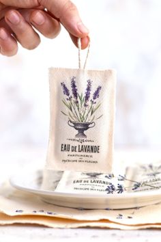 a person is holding a bag with lavender on it and the tag says eau de lavande