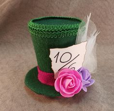 The Mad Hatter's hat. Perfect for teatime and parties. The item pictured may be slightly different from what you see.  This top hat is roughly 3.5 inches tall. Has 2 alligator clips on the bottom. Handmade with custom templates. You are always welcome to commission a custom order. Feel free to send us a message for any questions. Novelty Mini Cap Hat For Gifts, Whimsical Fedora Hat As Gift, Novelty Mini Hats With Curved Brim For Gifts, Novelty Mini Hat With Curved Brim As Gift, Kentucky Derby Gift Top Hat With Short Brim, Kentucky Derby Short Brim Top Hat Gift, Novelty Short Brim Hat As A Gift, Novelty Short Brim Hat As Gift, Novelty Brimmed Hat Gift