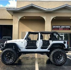 a white jeep parked in front of a building