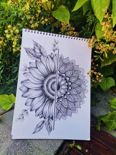 a drawing of a sunflower with leaves and flowers around it on a table next to some plants