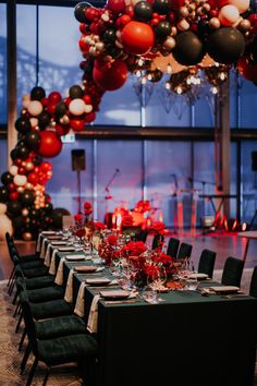 a long table is set with black, red and white balloons