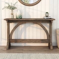 a wooden bench sitting in front of a wall with a mirror on top of it