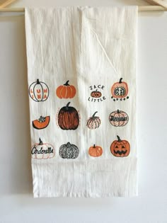 a kitchen towel hanging on a clothes line with pumpkins and jack - o'- lanterns