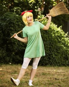 a woman in a green shirt holding a broom