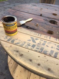 a can of food sitting on top of a wooden table next to a paintbrush