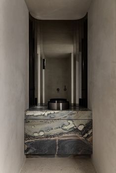 a bathroom with marble counter tops and sinks in the middle, along with two urinals on either side of the wall