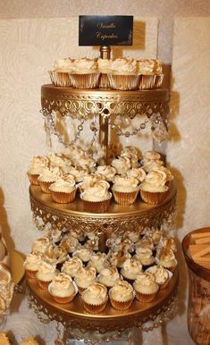 a three tiered cake with cupcakes on it