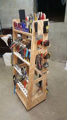 a wooden shelf filled with lots of tools and gadgets on top of cement flooring