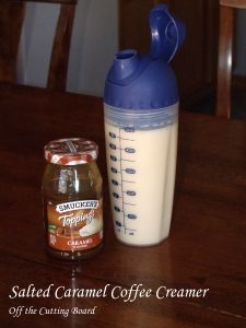 a blender sitting on top of a wooden table next to a jar of coffee