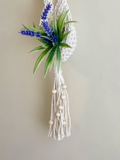 a crocheted white wall hanging with blue flowers