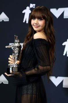 a woman in black dress holding an award for best female pop vocal performance at the vmas awards