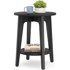 a table with a book and cup on it next to a potted green plant