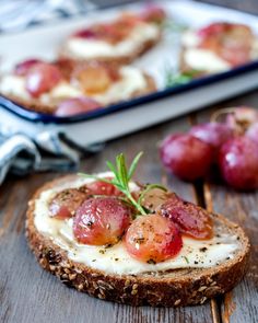 a close up of bread with cheese and grapes on it