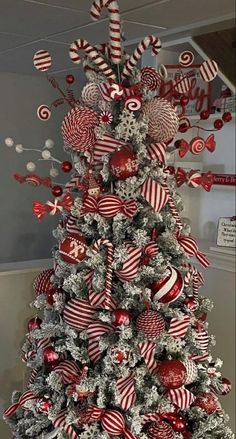 a christmas tree decorated with candy canes and ornaments in red, white and silver