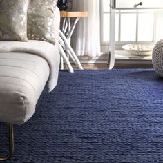 a living room with a blue rug on the floor and a couch in front of it