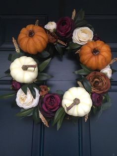 a wreath made out of fake flowers and pumpkins