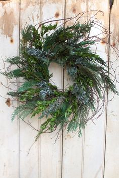 a wreath hanging on the side of a wooden door