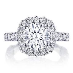 a diamond engagement ring with two rows of diamonds on the band and an oval center stone surrounded