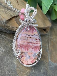 This unique Rhodochrosite stone has different shades of pink, gray and cream.  It has been wrapped with handwoven sterling silver and accented with a sterling silver bead and faceted pink Rhodonite beads.  An adjustable 16-18 inch sterling silver chain completes this beautiful necklace. Wire Jewelry Patterns, Pink Rhodonite, Pink Rhodochrosite, Different Shades Of Pink, Wrapped Necklace, Wrap Jewelry, Handmade Wire Wrapped, Wire Wrapped Necklace, Handmade Wire