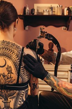 a tattooed woman getting her tattoo done