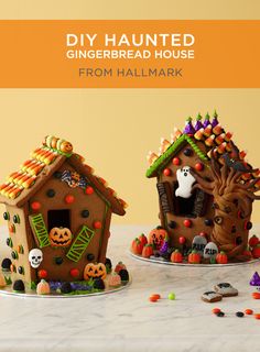 two decorated gingerbread houses sitting on top of a table next to candy and sprinkles