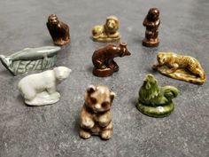 there are many small figurines on the table together, including bears and other animals