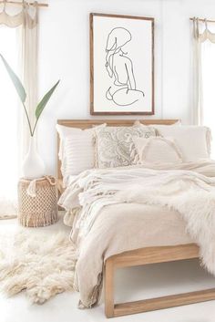 a bed with white sheets and blankets in a bedroom next to a window, rugs and a potted plant