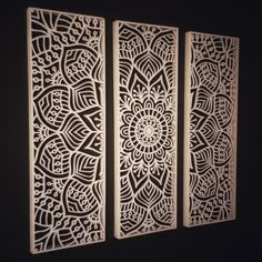 three panels with intricate laser cut designs on the sides, one in white and one in black