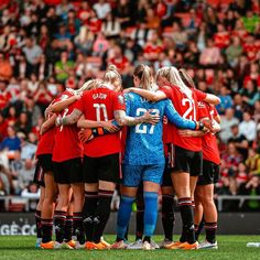 a group of women soccer players huddle together