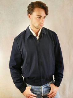 This 1980s vintage Air Force jacket has a wing collar with an optional buttoned strap at the neckline and zips closed in front. The handsome jacket features shoulder epaulets and has a ribbed and elasticated waistband and sleeve cuffs. Brand label: Patriot (Made in USA) Size: 40 US/UK Material: 55% polyester, 45% wool Condition: Excellent (Professionally Cleaned ... soft and supple, with no stains, tears, wear spots, or weaknesses in the seams) --- M E A S U R E M E N T S --- Chest = 42 inches ( Classic Collared Outerwear With Zip Fly, Retro Fitted Outerwear With Zipper Closure, Navy Fitted Retro Outerwear, Fitted Navy Retro Outerwear, Retro Collared Formal Outerwear, Retro Collared Outerwear For Formal Occasions, Air Force Jacket, Wing Collar, Military Coat