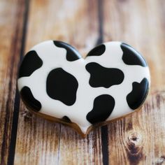 a black and white heart shaped cookie sitting on top of a wooden table