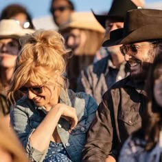 a group of people sitting next to each other in front of a man wearing a cowboy hat