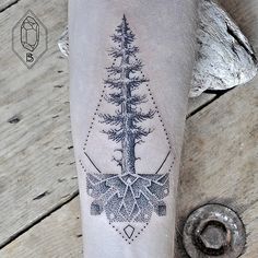 a tattoo on the leg of a person with a pine tree and snowflakes