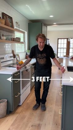 a man standing in the middle of a kitchen next to an oven and counter top