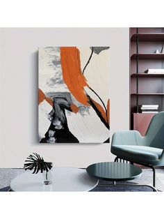 an abstract painting hangs on the wall next to a chair and table in a modern living room