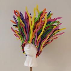 a white mannequin head with colorful streamers on it