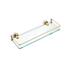 a glass shelf with two brass handles