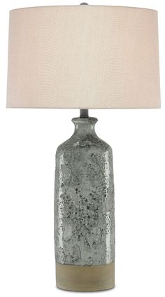 a table lamp with a white shade on it and a light brown base is next to the lamp